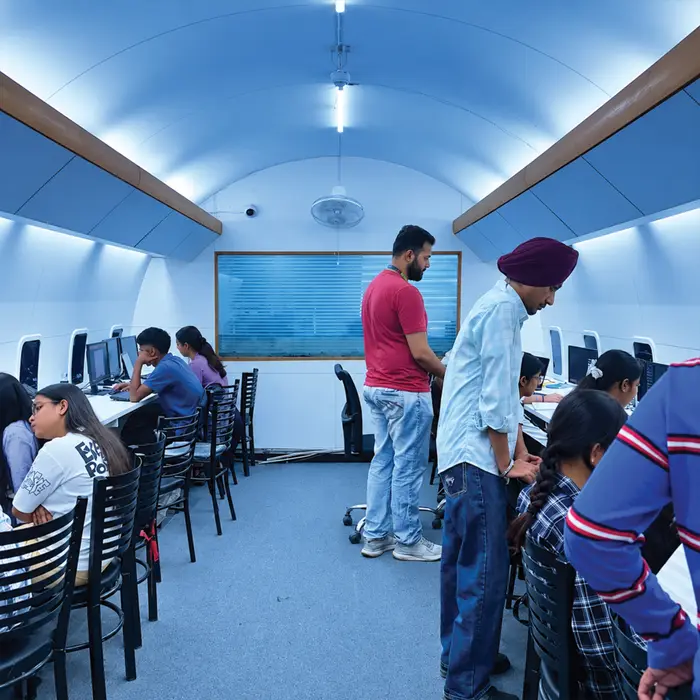 The aircraft-cabin lab, trainers helping students at their machines