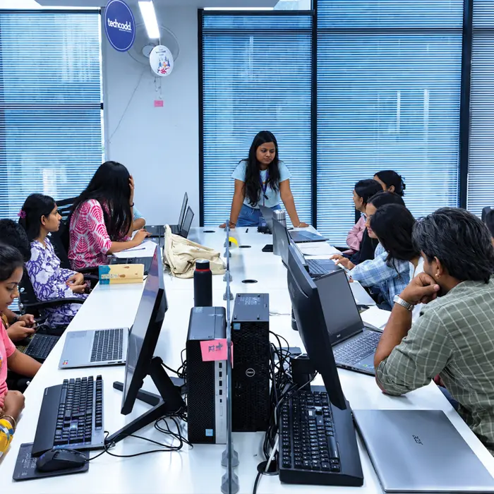 A trainer briefing a class across a long lab table