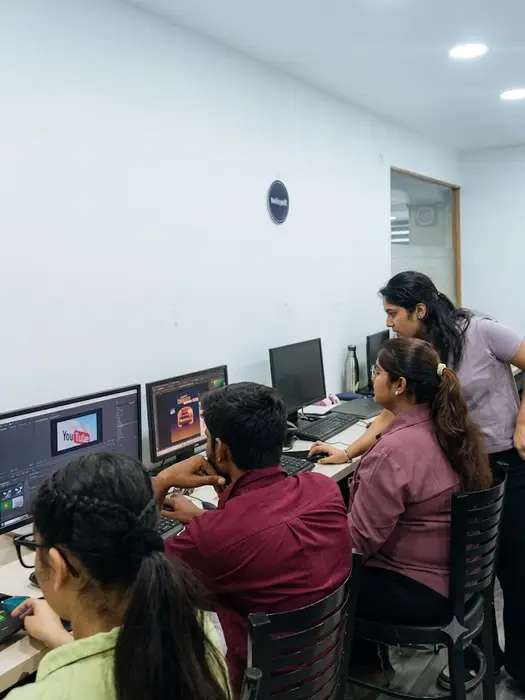 A trainer helping students with a video edit